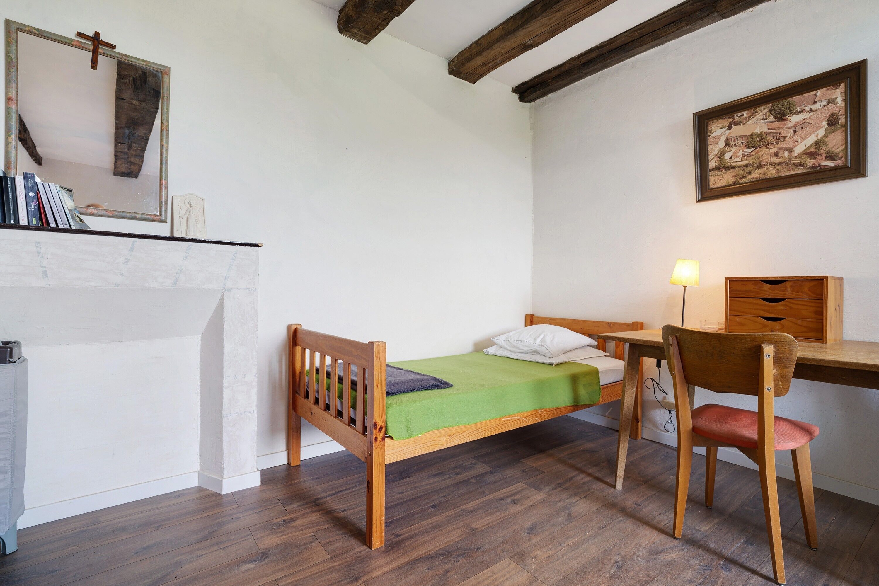 A bedroom with a wooden bed, a desk, and a chair.