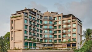 A multi-story hotel with balconies, large windows, and a central dome structure. - Goldfinch Hotel Mangaluru (Mangaluru)