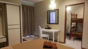 A hotel room with a bed, a desk, a chair, a mirror, and a wooden bunk bed. - Rovers Inn Tanah Rata (Tanah Rata)