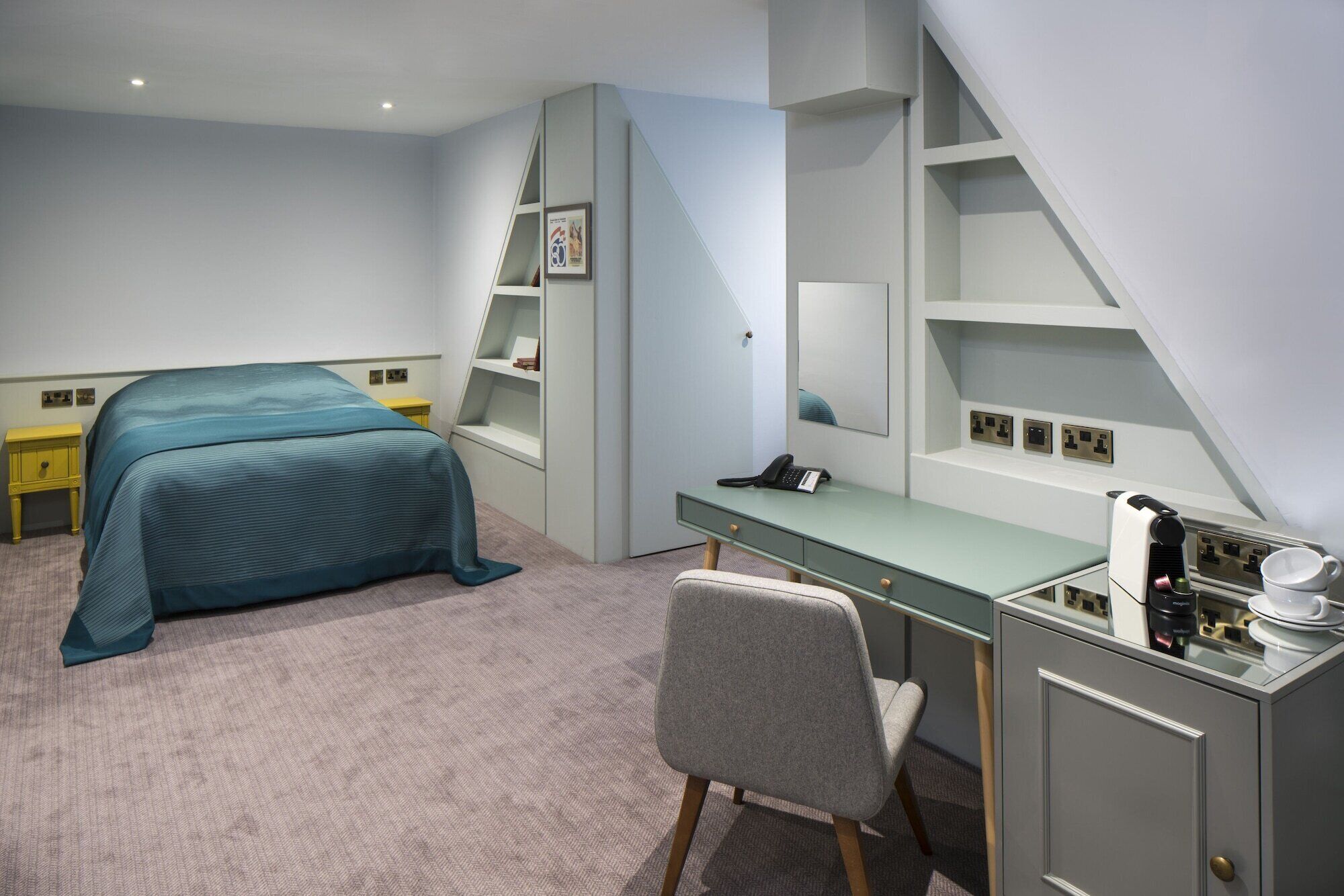Un dormitorio con cama, escritorio, silla y estanterías empotradas.