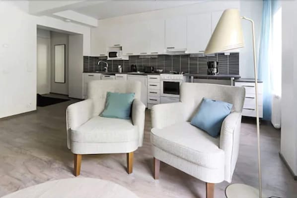 Een moderne woonkamer met twee fauteuils en een vloerlamp.