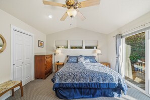 A bedroom with a bed, a ceiling fan, a dresser, a bench, and a window with blinds. - Ocean Views, Dogs Ok, Steps to the Beach & Walk to Town!-Manzanita Magic (Manzanita)