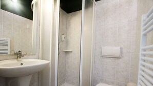 Une salle de bain avec un lavabo, des toilettes et une douche.