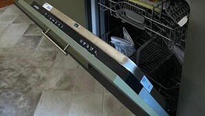 Una cocina moderna con lavavajillas integrado, pileta de acero inoxidable y extractor.