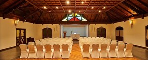 A church interior with pews arranged for seating, a wooden ceiling, and a stained glass window. - Club Mahindra Cherai (Kochi)