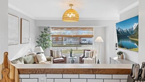 A modern kitchen with a wooden countertop, a hanging light fixture, and a view of a mountain landscape through the window. - Luxury Look in Plymouth I Walk to Downtown l Sleeps 8 I Hot Tub (Plymouth)