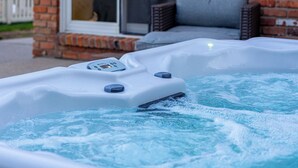 A hot tub outside a brick building with a sliding glass door. - Luxury Look in Plymouth I Walk to Downtown l Sleeps 8 I Hot Tub (Plymouth)
