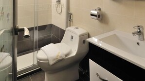 A modern bathroom with a glass shower enclosure, a toilet, a sink, and a mirror cabinet. - E Red Hotel Cosmo (Bukit Mertajam)