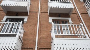 A multi-story building with white balconies and brick walls. - Guest House Les 3 Metis (Antananarivo)
