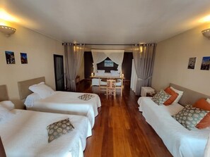 A hotel room with two beds, a dining table, and a small seating area. - Guest House LES 3 Metis (Antananarivo)