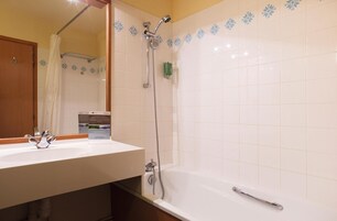 Une salle de bain avec une douche, un lavabo et un miroir.