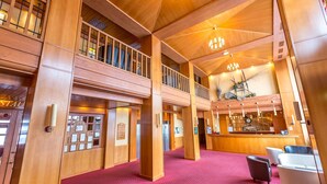 A spacious lobby with wooden architecture, a reception desk, and a red carpeted floor. - Hotel La Plagne Le Terra Nova - Winter (La Plagne-Tarentaise)