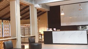 A modern interior with a kitchen area, seating, and a large white marble countertop. - Khanom Maroc Resort and Spa (Khanom)