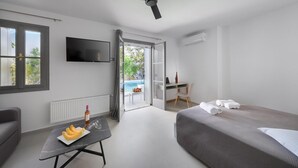 Une chambre d’hôtel moderne équipée d’un lit, d’un bureau, d’une télévision et offrant une vue sur une piscine extérieure.