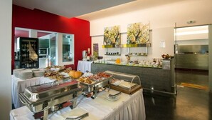 Un buffet proposant une variété de plats, un espace cuisine et un mur d’accent de couleur rouge.