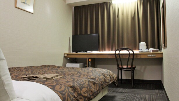 A hotel room with a bed, a desk with a computer, a chair, and a television. - Hotel 1 2 3 Kurashiki (Kurashiki)