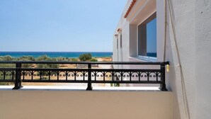 A balcony with a view of the sea and a white building with red tiles. - Iris Apartments and Rooms (Kantanos-Selino)