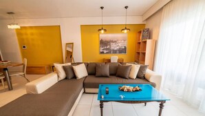 Una sala de estar moderna con un sofá seccional, una mesa de centro azul y un cuadro con una vista de la ciudad.
