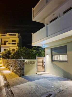 A modern two-story building with a stone wall and a metal gate. - Ammos Little Escape – Gonies (Iraklio)