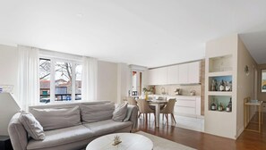 A modern apartment with a living room, dining area, and kitchen. - Residence d Exception – A 5 mins de La Defense (La Garenne-Colombes)