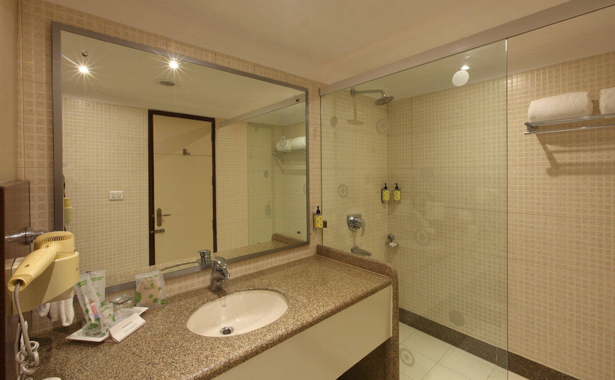 A bathroom with a sink, mirror, and shower.