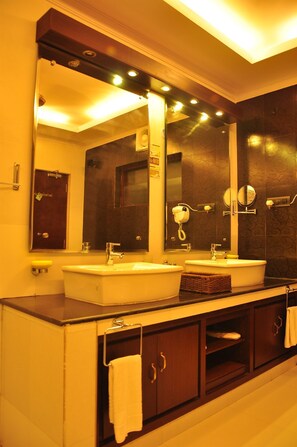 Une salle de bain avec deux lavabos, un grand miroir et un meuble-lavabo doté d’un porte-serviettes.