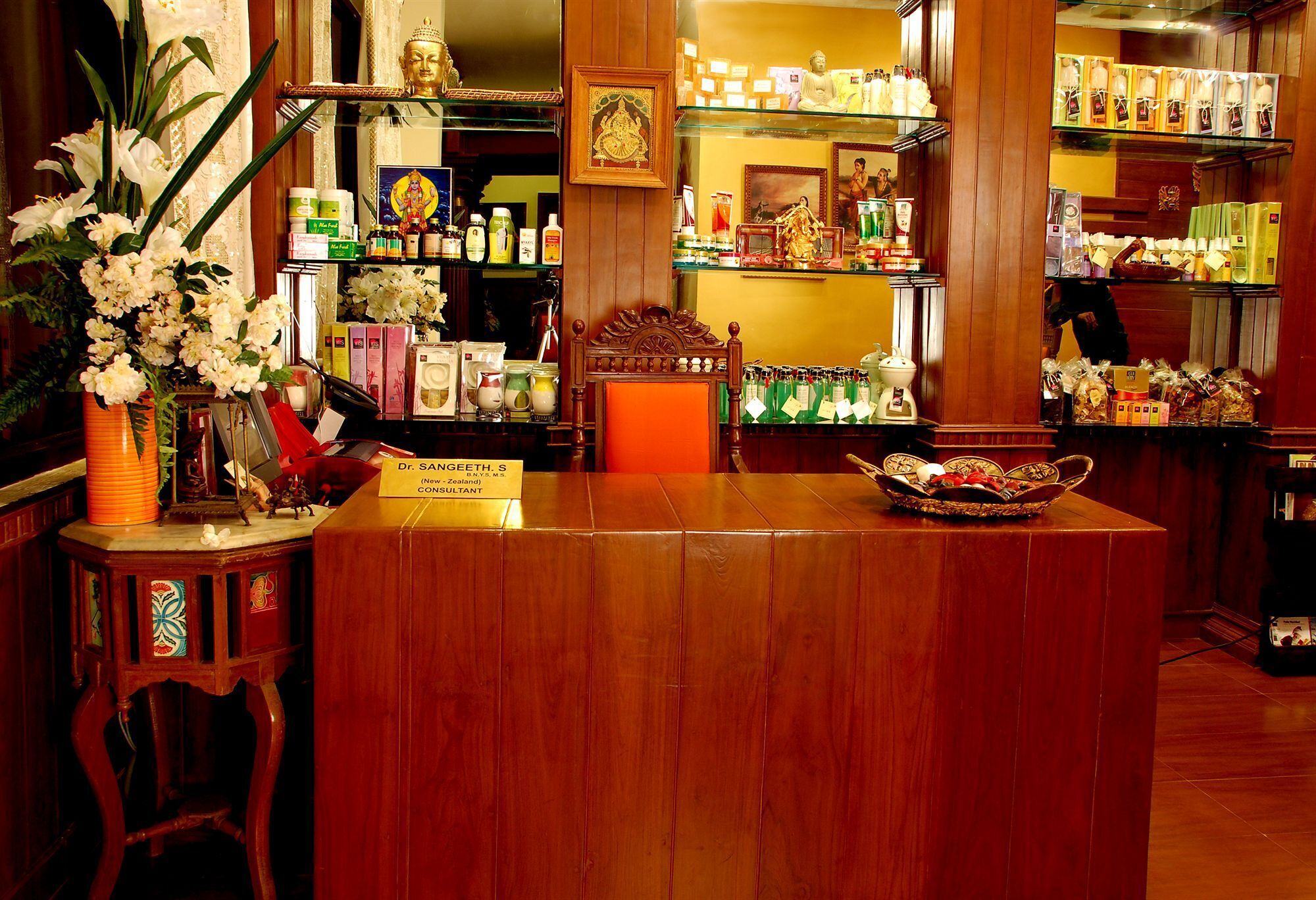 A reception desk with a wooden finish, a signboard, and a decorative chair.