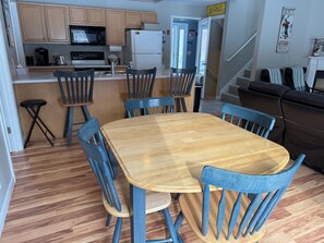 A compact kitchen with wooden cabinets, a microwave, and a refrigerator.