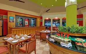 A hotel bar area with a buffet, seating arrangements, and a bar counter. - The Fern Kesarval Hotel & Spa Verna Plateau, Goa (Verna)