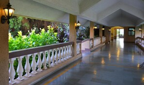 A corridor with a railing, columns, and wall-mounted lights. - The Fern Kesarval Hotel & Spa Verna Plateau, Goa (Verna)