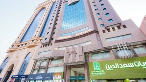 A tall hotel building with a prominent sign for ASFOUR HOTEL. - Asfour Hotel 03 (Makkah)