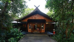 A wooden building with a peaked roof and a diamond-shaped design on the front. - Rimba Orangutan Eco Lodge (Kumai)