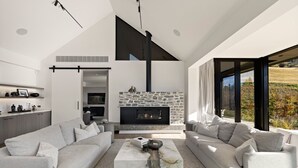 Un salon moderne avec une cheminée en pierre, un grand canapé d’angle et un design minimaliste.