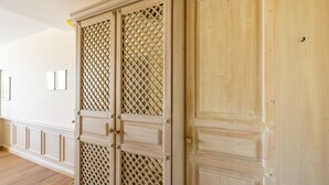 A hallway with wooden flooring, a white wall with two framed pictures, and a wooden door with a lattice design. - Liebevoll Eingerichtetes Studio am Kurpark in Bad Birnbach (Bad Birnbach)