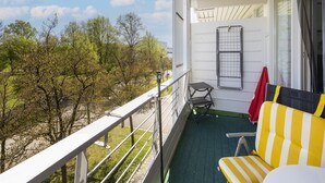 A balcony with a metal railing, a chair, a small table, and a drying rack. - Liebevoll Eingerichtetes Studio am Kurpark in Bad Birnbach (Bad Birnbach)