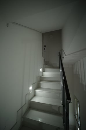 Eine Treppe mit weißen Wänden und einem Metallgeländer.