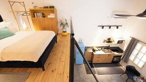 Una camera da letto con un letto, un'armadio in legno, una piccola scrivania e una finestra.