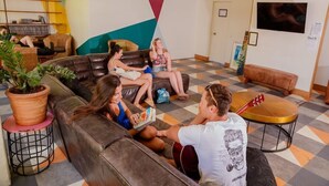 A modern lounge area with leather sofas, a coffee table, and a guitar. - Bunk Backpackers Surfers Paradise Hostel (Gold Coast)