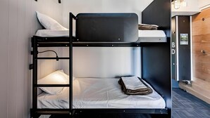 A bunk bed room with a wooden wardrobe, a small desk, and a wall-mounted light fixture. - Bunk Backpackers Surfers Paradise Hostel (Gold Coast)
