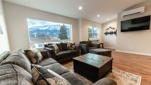 A modern living room with a sectional sofa, a coffee table, and a TV.