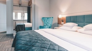 A hotel room with a bed, a chair, a nightstand, and a mirror. - Aparthotel Fortune (Poznań)