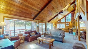 A spacious lodge with wooden interiors, large windows, and a cozy seating area.