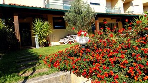 A residential building with a balcony, a garden with red flowers, and a white lamp post. - DREAM HOUSE at Douro Valley with river view at 30Kms of Porto (PENAFIEL)
