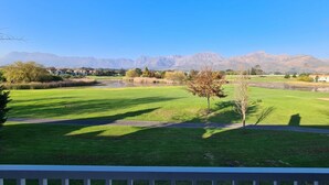 Campo de golf con una vista despejada de montañas al fondo.