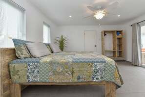 Ein Schlafzimmer mit einem hölzernen Bett, einem Deckenventilator und einer eingebauten Holzregaleinheit.