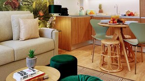 Ein modernes Wohnzimmer mit einer Couch, einem Couchtisch und einem Essbereich mit Stühlen und einem Tisch.