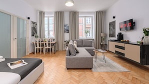 Una sala de estar moderna con un sofá, una mesa de comedor y un televisor.