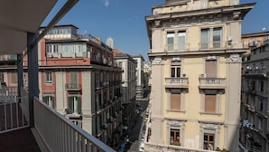 A narrow street lined with multi-story buildings, balconies, and air conditioning units. - Naples Royal House B&B (Naples)