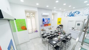 A dining area with multiple tables, chairs, and a staircase. - Naples Royal House B&B (Naples)