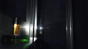 A room with a large window, a metal railing, and a view of a cityscape at night. - Naples Royal House B&B (Naples)